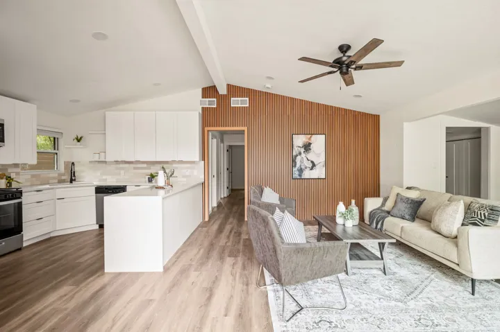 Open kitchen and living room with a slatted wood wall