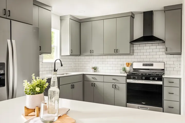 Gray European flat-panel kitchen with subway tile and gas range