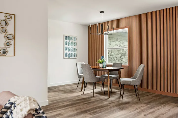 Dining area with a wood slat accent wall